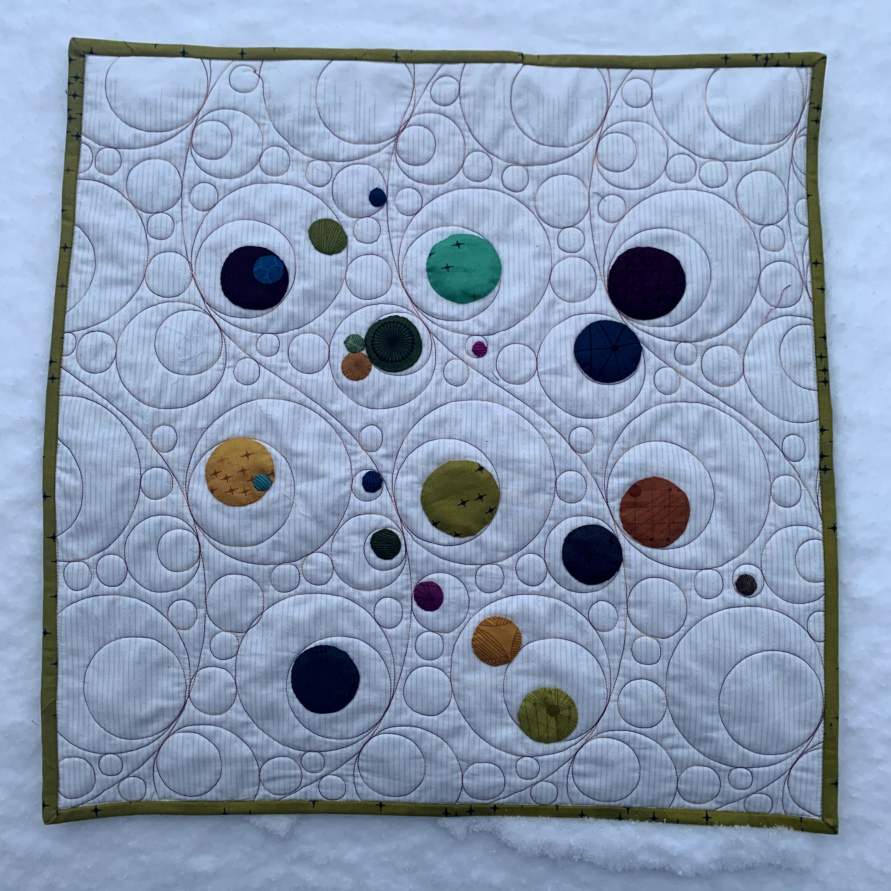 quilt with circle appliqués and circular quilting
