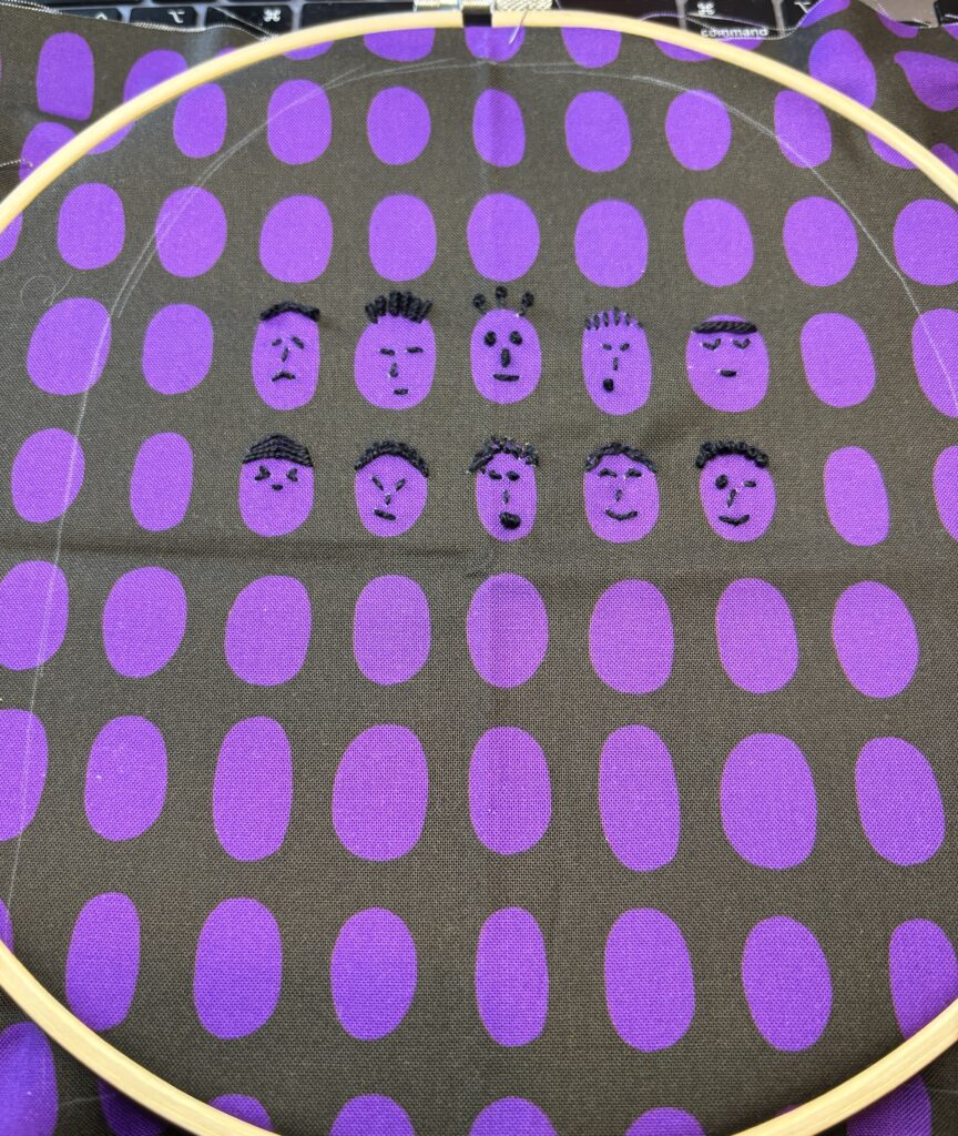 embroidered faces on purple oval printed fabric. Night rainbow blog hop and playtime. 